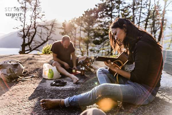 Mann und Frau entspannen sich  kochen Essen und spielen Gitarre auf The Malamute  Squamish  Kanada