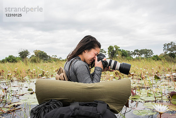 Junge Touristin beim Fotografieren im Okavango-Delta  Botswana  Afrika