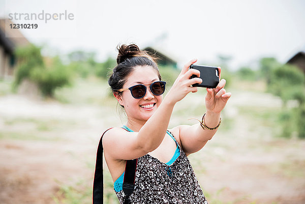 Junge Touristin beim Smartphone-Selfie  Botswana  Afrika