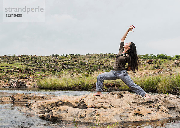 Junge Touristin  die in Bourkes Potholes  Mpumalanga  Südafrika  eine Yoga-Kriegerpose einnimmt