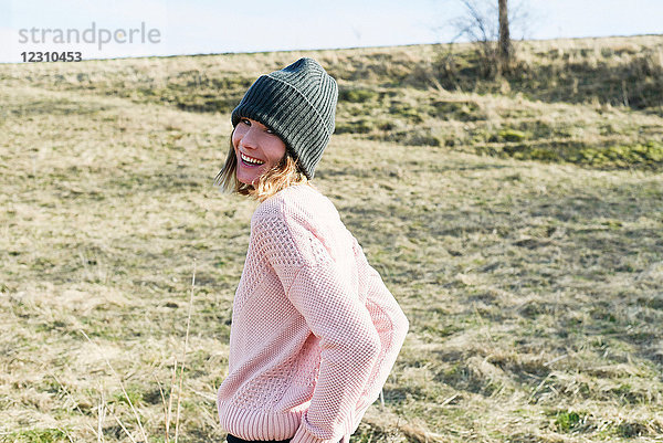 Porträt einer mittleren erwachsenen Frau mit Strickmütze im Feld