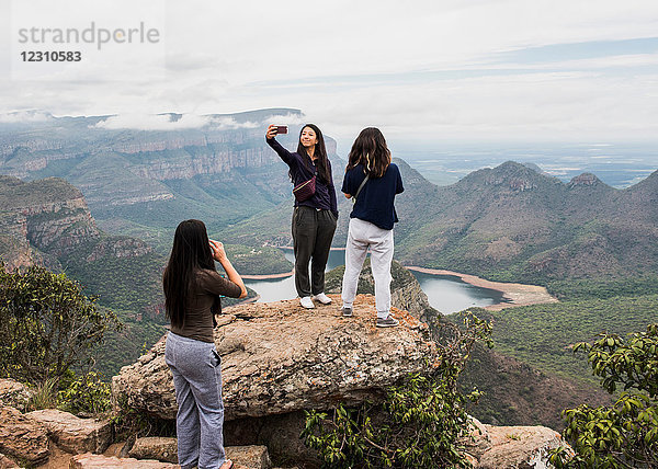 Drei junge Touristinnen  die aus den Three Rondavels  Mpumalanga  Südafrika  Ausschau halten und sich selbst etwas nehmen