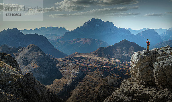 Bergsteiger am Fels mit Blick auf Gebirgsketten  Dolomiten  Cortina d'Ampezzo  Venetien  Italien