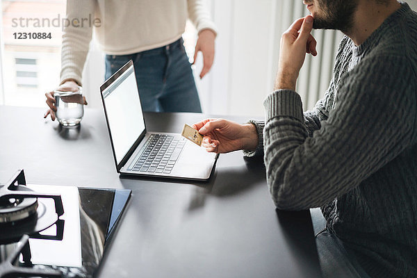 Paar mit Kreditkarte mit Laptop  beschnitten