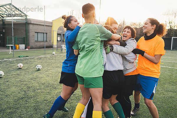 Fussballspieler jubeln und umarmen sich auf dem Platz