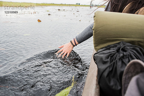 Weibliche Touristin im Okavango-Delta  Detail der Hand im Wasser  Botswana  Afrika