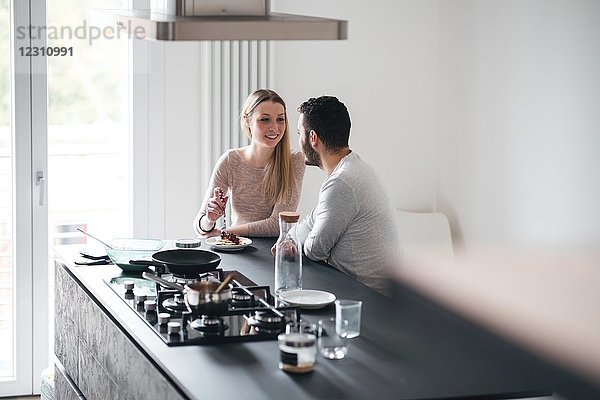 Ehepaar in der Küche an der Frühstücksbar