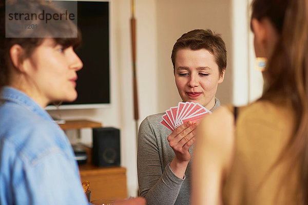 Freunde spielen Karten im Wohnzimmer