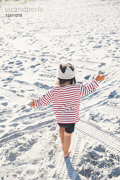 Kleines Mädchen spielt am Strand