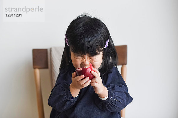 Kleines Mädchen beißt in Apfel