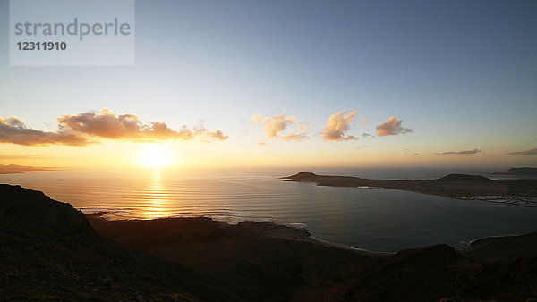 Spanien. Kanarische Inseln. Lanzarote. Aussichtspunkt Mirador del Rio. Sonnenuntergang an der Küste und auf der Insel Graciosa.