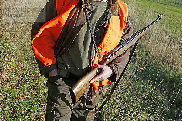 Departement Aisne. Großwildjagdsaison (Herbst). Jäger hält ein Gewehr in den Händen.