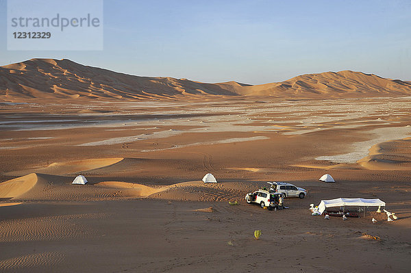 Sultanat Oman  Dhofar  Rub Al Khali Wüste  genannt das leere Viertel  das größte Sandgebiet der Welt  Grenze von Jemen und Saoudi Arabien  ein Touristencampingplatz mit 2 4 Rädern ist verloren in der Mitte einer ockerfarbenen Sandwüste