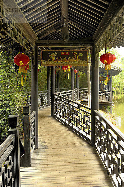 China  Jiangsu  Suzhou  überdachte Holzbrücke in einem der Klassischen Gärten von Suzhou