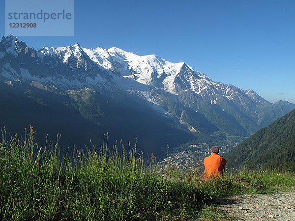 Haute Savoie  Tour du mont blanc  ein Mann genießt die Aussicht oberhalb von Chamonix auf den Mont blanc von La Flegere aus