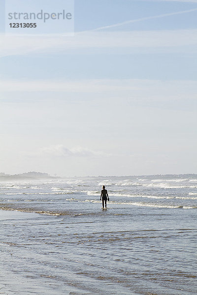 Frankreich  Saint-Jean-de-Monts  junge Frau beim Spaziergang im Meer.