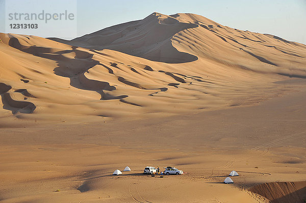 Sultanat Oman  Dhofar  Rub Al Khali Wüste  genannt das leere Viertel  das größte Sandgebiet der Welt  Grenze von Jemen und Saoudi Arabien  ein Touristencampingplatz mit 2 4 Rädern ist verloren in der Mitte einer ockerfarbenen Sandwüste