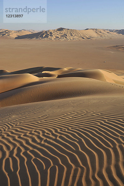 Sultanat Oman  Dhofar  Rub Al Khali Wüste  genannt das leere Viertel  das größte Sandgebiet der Welt  Grenze von Jemen und Saoudi Arabien  ein weißes 4 Räder ist in der Mitte einer ockerfarbenen Sandwüste verloren