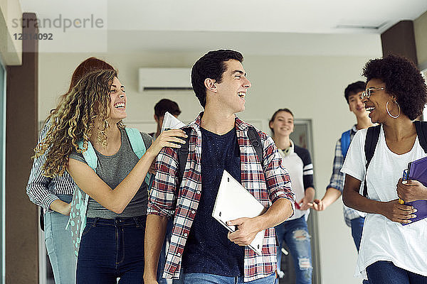 Lachende Studenten beim gemeinsamen Spaziergang auf dem Campus