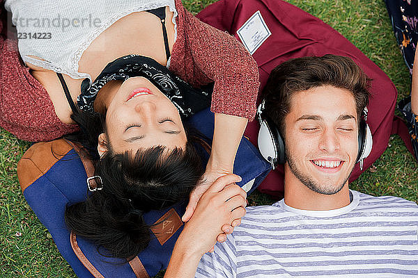 Junges Paar entspannt sich gemeinsam im Gras  Blick von oben
