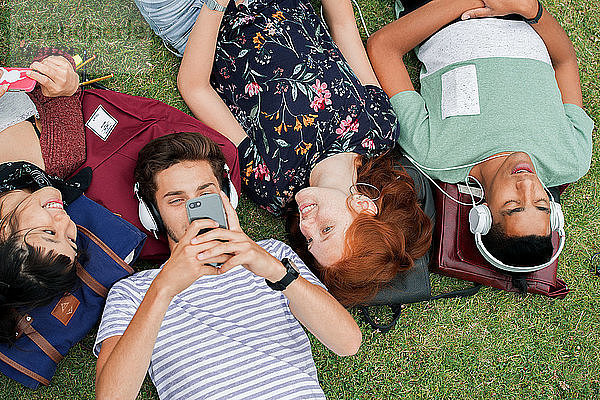 College-Freunde entspannen sich gemeinsam auf dem Rasen