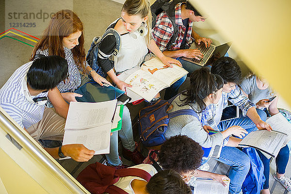 Gruppe von Studenten  die gemeinsam im Treppenhaus lernen
