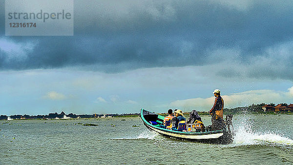 Shan-Staat  Myanmar (Burma)  Asien; Langes Holzboot und einheimische Passagiere auf dem Inle-See.