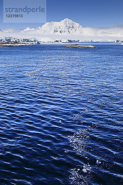 Nebliger Mount William unter blauem Himmel  vom Meer aus vor Anvers Island  Antarktische Halbinsel  Antarktis  Polarregionen