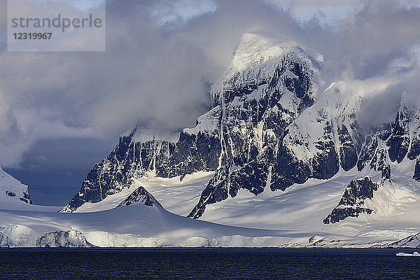 Gletscher und Berge von Kap Errera mit dramatischem Himmel  Wiencke Island  von der Bismarckstraße aus  Antarktische Halbinsel  Antarktis  Polarregionen