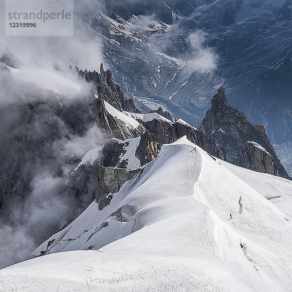 Blick über den Grat hinunter ins Vallee Blanche  wo eine kleine Gruppe von Bergsteigern ins darunter liegende Vallee absteigt  Chamonix  Haute Savoie  Rhone Alpes  Frankreich  Europa