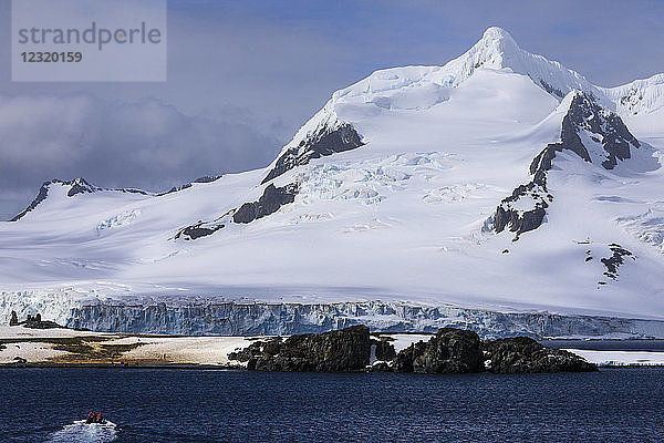 Touristen in einem Zodiac-Boot nähern sich der Halbmondinsel  Bergkulisse der Livingston-Insel  Süd-Shetland-Inseln  Antarktis  Polarregionen