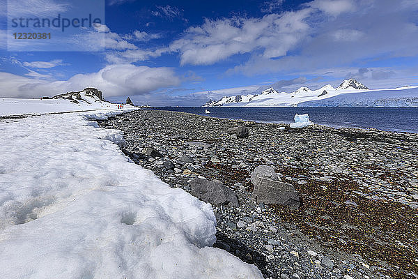 Expeditionstouristen spazieren am Ufer von Half Moon Island  Blick auf Livingston Island  blauer Himmel  Süd-Shetland-Inseln  Antarktis  Polarregionen