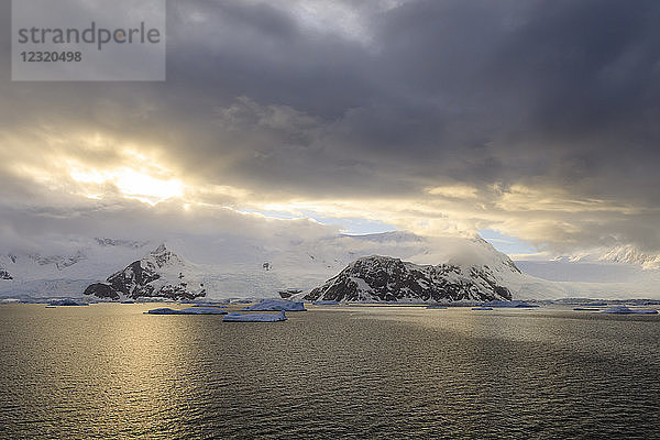 Sonnenaufgang  mit atmosphärischen Wolken und Nebel  Berge  Gletscher und Eisberge  Neko Harbour  Andvord Bay  Graham Land  Antarktis  Polarregionen