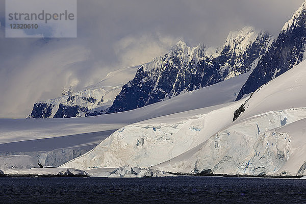 Gletscher  Berggipfel und dramatische Wolken und Himmel  Kap Errera  Wiencke Island  Antarktische Halbinsel  Antarktis  Polarregionen