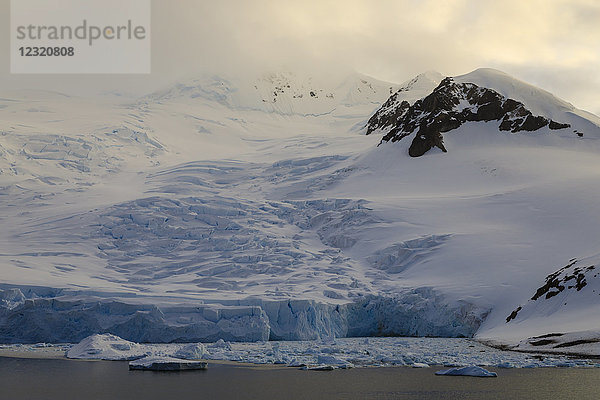 Gletscher bei Sonnenaufgang  mit atmosphärischen Wolken und Nebel  Neko Harbour  Andvord Bay  Graham Land  Antarktis  Polarregionen