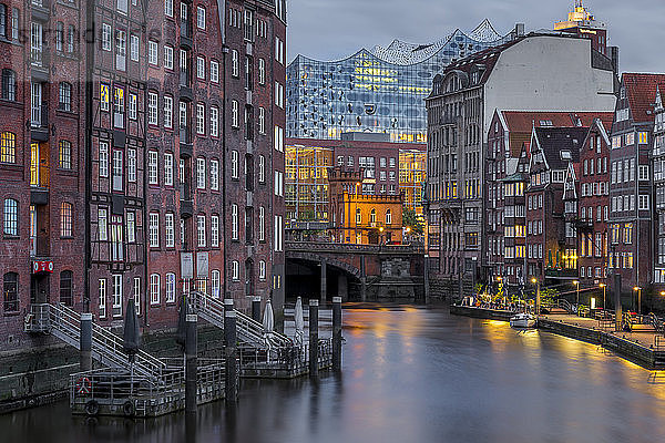 Historische Gebäude am Nikolaifleet mit Blick auf die Elbphilharmonie im Hintergrund in der Abenddämmerung  Hamburg  Deutschland  Europa