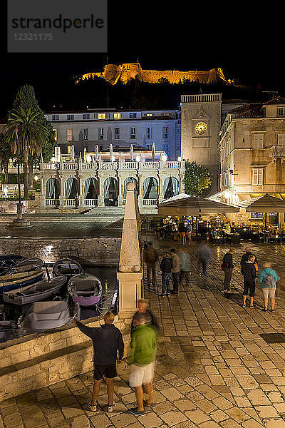 Nachtaufnahme des Hauptplatzes (Trg Svetog Stjepana) der Stadt Hvar mit Blick auf die Spanische Festung im Hintergrund  Hvar  Kroatien  Europa