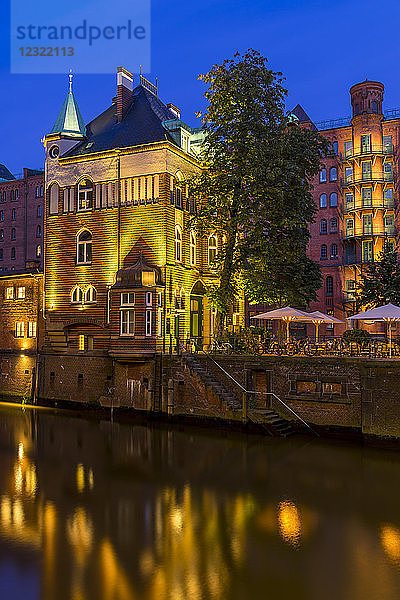 Beleuchtetes Wasserschlösschen-Gebäude in der historischen Speicherstadt in der Abenddämmerung  Hamburg  Deutschland  Europa