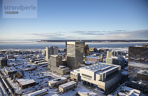 Luftaufnahme des Conoco Phillips-Gebäudes in der Innenstadt von Anchorage  Schnee bedeckt den Parkstreifen im Vordergrund  Point MacKenzie im Hintergrund im Winter  Süd-Zentral-Alaska; Anchorage  Alaska  Vereinigte Staaten von Amerika