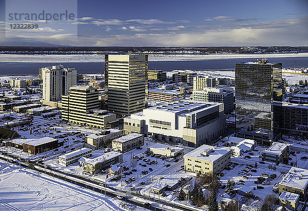 Luftaufnahme des schneebedeckten Parkstreifens und der Gebäude der Innenstadt von Anchorage im Hintergrund  Meereis um Point MacKenzie im Hintergrund im Winter  Süd-Zentral-Alaska; Anchorage  Alaska  Vereinigte Staaten von Amerika