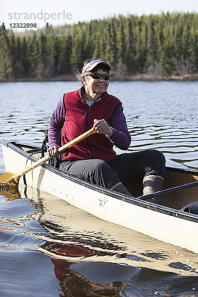 Frau steuert ein Kanu im Gebiet des Swanson Lake  Kenai-Halbinsel  Süd-Zentral-Alaska; Alaska  Vereinigte Staaten von Amerika