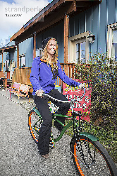 Junge Frau auf einem Fahrrad in der Innenstadt von Anchorage  Süd-Zentral-Alaska; Anchorage  Alaska  Vereinigte Staaten von Amerika