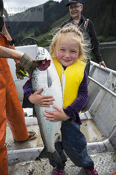 Junges Mädchen hält einen Lachs in einem Stellnetz-Skiff  Süd-Zentral-Alaska; Seldovia  Alaska  Vereinigte Staaten von Amerika