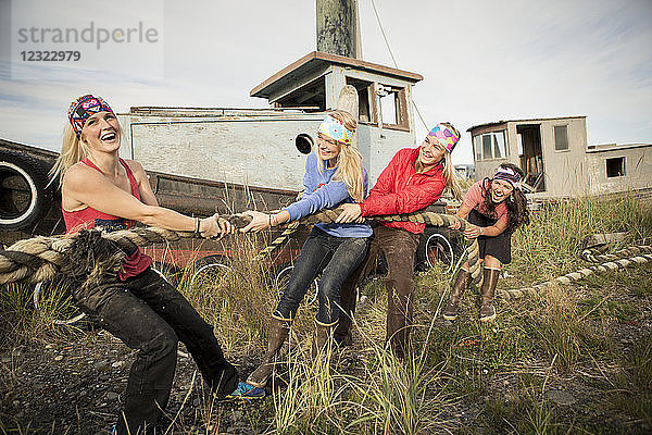 Gruppe von Freunden spielt Tauziehen mit einem großen Seil entlang der Küste von Homer  Süd-Zentral-Alaska; Homer  Alaska  Vereinigte Staaten von Amerika