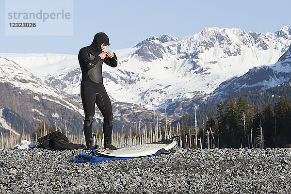 Surfer bei den Vorbereitungen zum Surfen an der Außenküste der Kenai-Halbinsel  Süd-Zentral-Alaska; Alaska  Vereinigte Staaten von Amerika