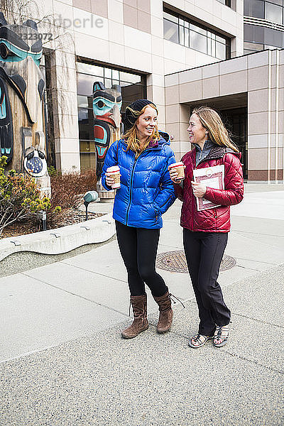 Zwei junge Frauen hängen in der Innenstadt von Anchorage  Süd-Zentral-Alaska  ab; Anchorage  Alaska  Vereinigte Staaten von Amerika