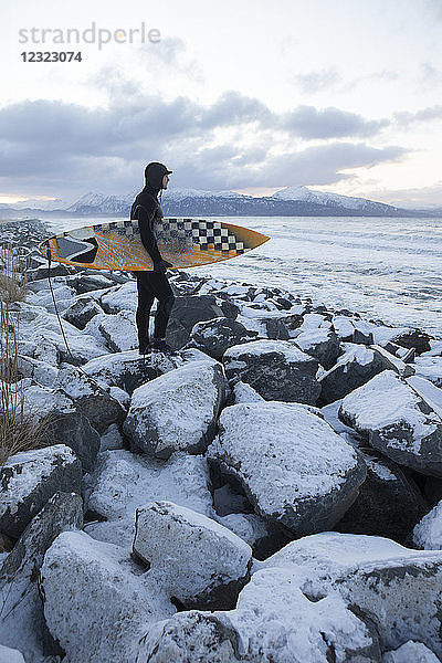 Surfer bei der Vorbereitung zum Surfen im Winter in der Nähe von Homer  Süd-Zentral-Alaska; Alaska  Vereinigte Staaten von Amerika