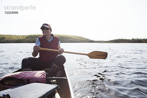 Frau steuert ein Kanu im Gebiet des Swanson Lake  Kenai-Halbinsel  Süd-Zentral-Alaska; Alaska  Vereinigte Staaten von Amerika