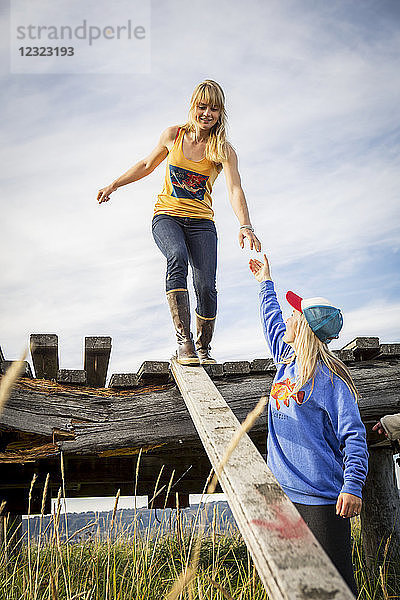 Zwei Schwestern erkunden einen alten Holzsteg in der Nähe von Homer  Süd-Zentral-Alaska; Homer  Alaska  Vereinigte Staaten von Amerika