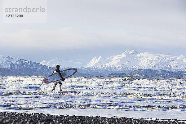 Surfer mit Surfbrett in der Kachemak Bay  Süd-Zentral-Alaska; Homer  Alaska  Vereinigte Staaten von Amerika